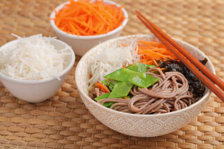 Soba noodle soup with nori seaweed sheets, green beans, carrot, and daikon radishの写真素材