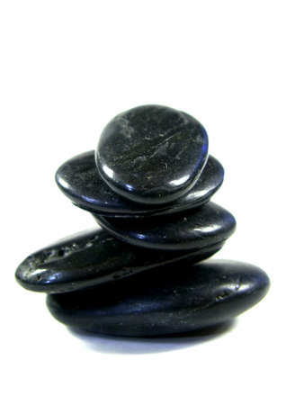 rocks carefully stacked isolated on white. shallow depth of field. focus on top rock.の写真素材