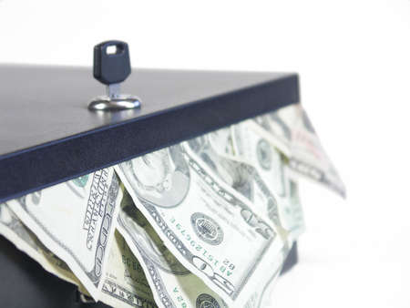 lockbox with US bills sticking out with key in box. shallow depth of field. focus on box in front of keyの写真素材