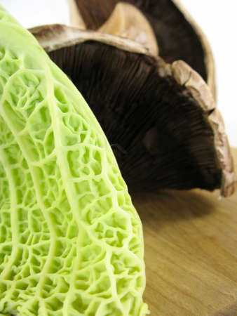 Close up of green cabbage with portabello on a cutting board. Very shallow depth of field.の写真素材