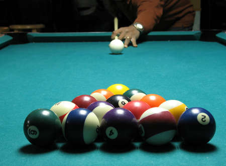 Man standing at end of pool table ready to shoot.