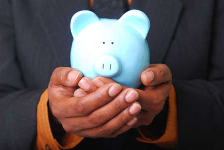 African-American male hands cradling a piggy bank.の写真素材