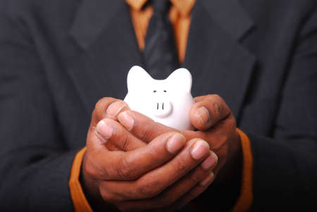 African-American male hands cradling a piggy bank.の写真素材