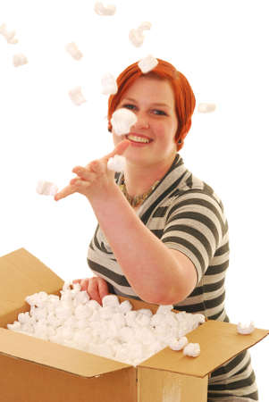 An attractive young woman excited about a recent delivery throwing packing material into the air.の写真素材