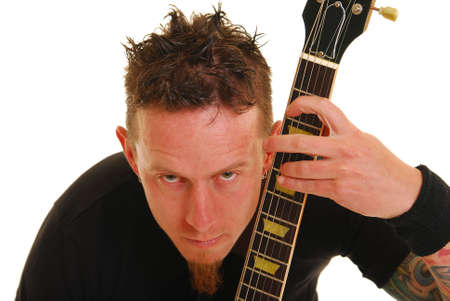 Caucasian man with tattoos on arms holding a guitar.