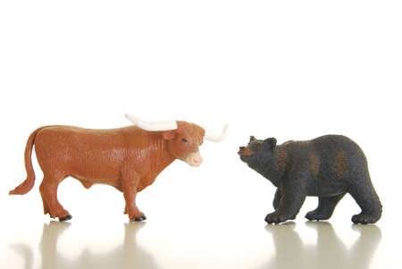 Miniature bull and bear photographed on white symbolizing financial marketsの写真素材