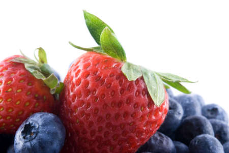 Pile of fresh blueberries with two strawberries on top.