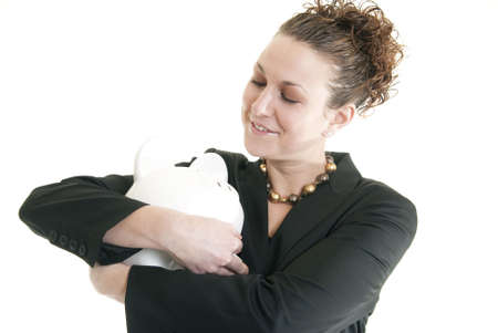 Beautiful, smiling Caucasian woman hugging a piggy bankの写真素材