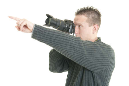 A young male photographer points while holding his cameraの写真素材