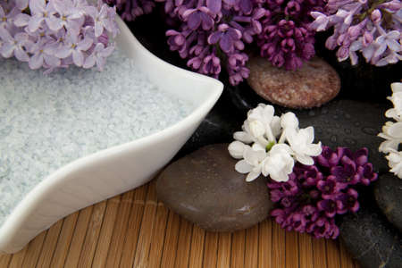 Different color lilacs with stones and bath salt on a bamboo mat.の写真素材