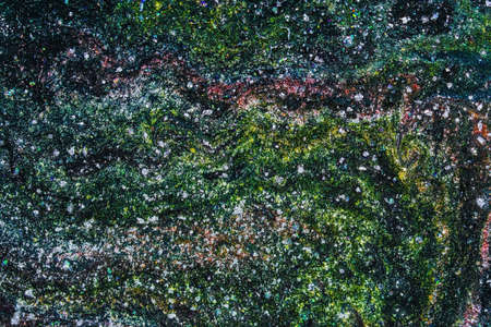 Handmade modern abstract painting of silver, black, green and red. Made with fluid acrylic paints, by acrylic pouring with silicone and torching. Useable as a background or texture.の写真素材