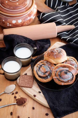 Spiral buns with poppy seeds and raisins on the table の写真素材