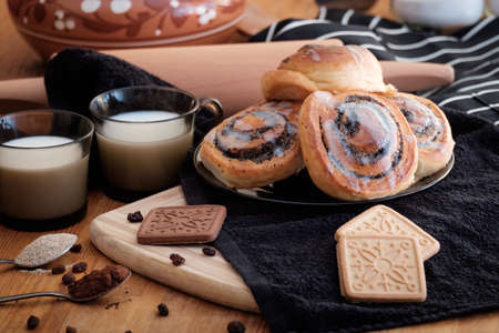 Spiral buns with poppy seeds and raisins on the table の写真素材