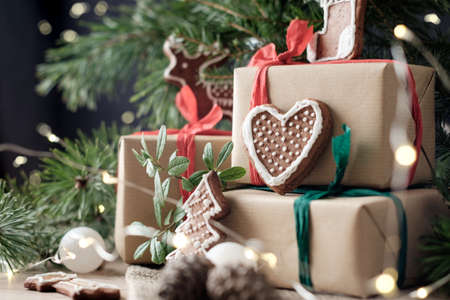 Close up photo of a cookies on wrapped gift boxes under a christmas treeの写真素材