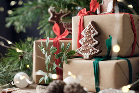 Close up photo of a cookies on wrapped gift boxes under a christmas treeの写真素材