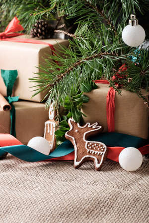 Close up photo of a cookies on wrapped gift boxes under a christmas treeの写真素材