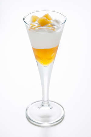 Cup of yogurt with peach jam and some decorative peach pieces on a white の写真素材