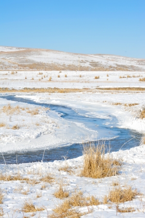 Tortuous river partly covered with iceの写真素材