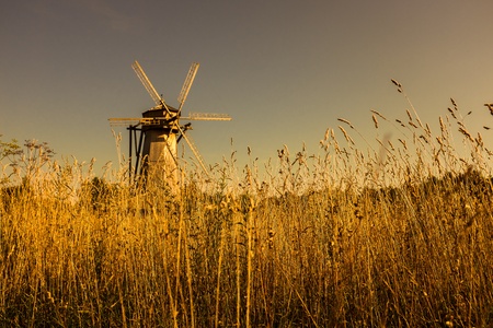 Wooden windmill on the field in the sunset color