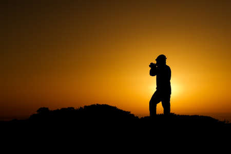 A silhouette of cameraman with golden light in the morning.の写真素材