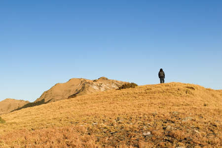 A man stand on the mountain with golden sunshine.の写真素材