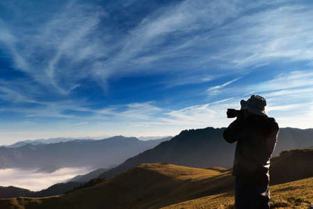 A cameraman standed and shot whith clouds in the outdoor.の写真素材