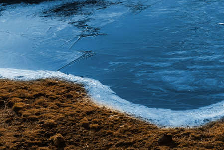 Beautiful strange iced pond surface and grass.の写真素材