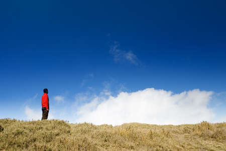 There is a man stand in the beautiful blue sky.の写真素材