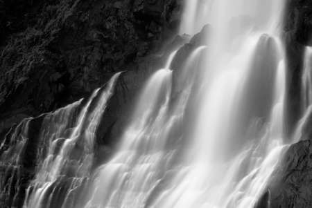 It is dramatic blurred view of waterfall flowing over rocks.の写真素材