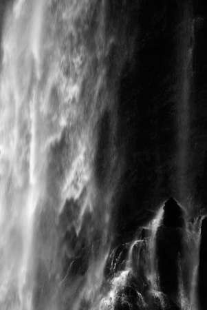It is dramatic blurred view of waterfall flowing over rocks.の写真素材