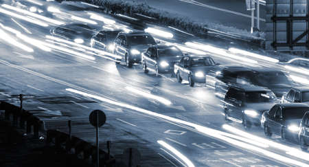 It is a cityscape of cars in the road with yellow blured light.の写真素材