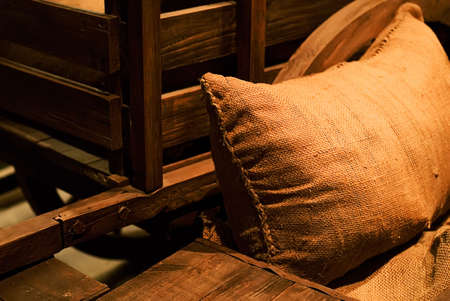 It is a bag of goods lay against the wooden wheel.の写真素材