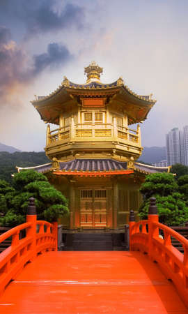 Golden buddhism tower with red bridge and blue sky in China.の写真素材