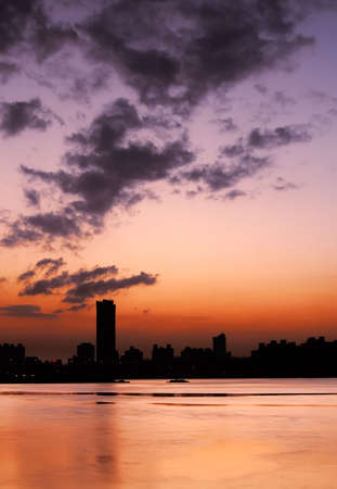 Silhouette of city near river under the dramatic sky in Taipei, Taiwan.の写真素材