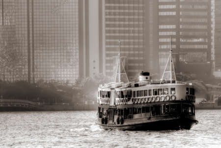 Boat on Victoria harbour in Hongkong with tall buildings.の写真素材