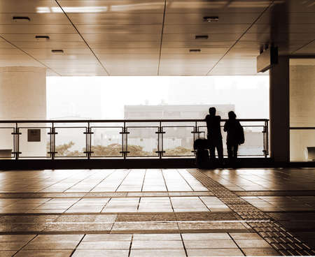 Couple silhouette carry luggage to travel in the station.の写真素材