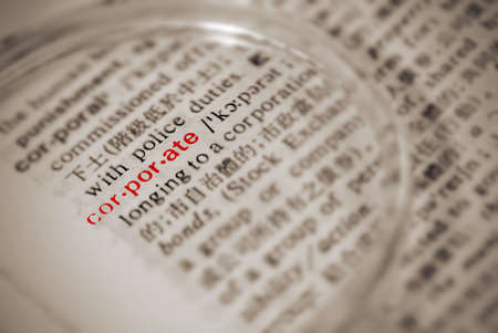 Corporate definition in dictionary with magnifier in yellow color.