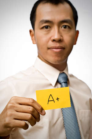 A plus sign on yellow card holding by businessman of Asian.