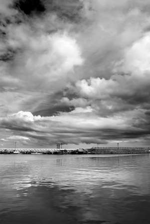 Landscape of dramatic nature scenic with boats on sea port under storm clouds.