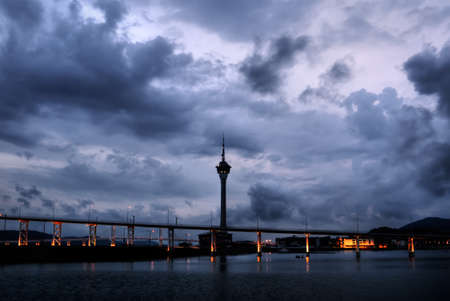 Cityscape in Macao with dramatic clouds and travel tower silhouette in night.のeditorial素材