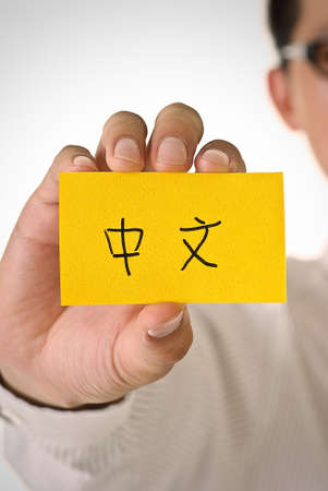 Chinese words on yellow card hold by business man.の写真素材