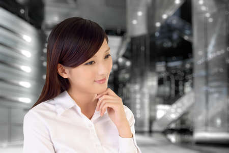 Businesswoman thinking inside of modern architecture, closeup portrait of oriental office lady.の写真素材