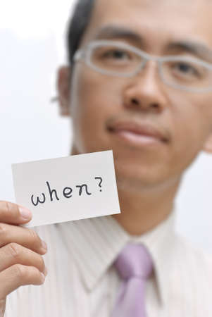 Manager ask you ¡§when¡¨ and holding one card with words.の写真素材