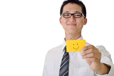 Smiling business man holding yellow card with smiling face, focus on face. Closeup portrait with white copyspace.の写真素材