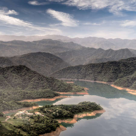 Landscape of countryside in tranquility with lake and mountains under blue sky.の写真素材
