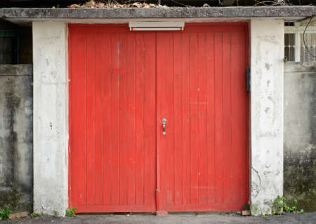 Old door in red color, desolate building exterior.の写真素材