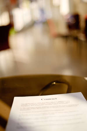 Business contract on desk in empty room, shallow DOF.の写真素材