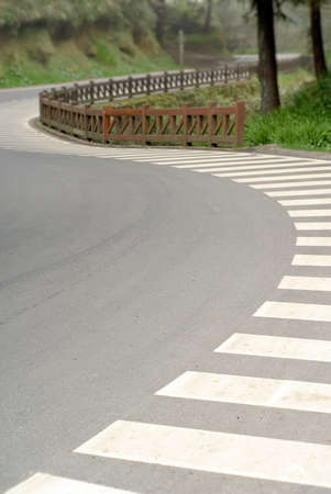 Zebra crossing in beautiful curve on road in forest in Alishan National Scenic Area, Taiwan, Asia.の写真素材