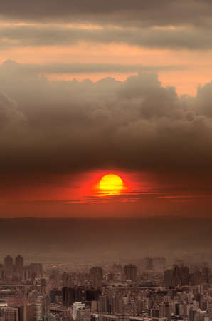 Sunset city scenery with red sun over buildings and clouds in Taipei, Taiwan, Asia.の写真素材