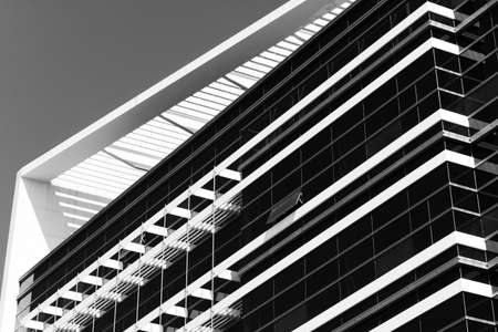 Modern architecture with glass of windows under blue sky.